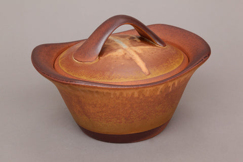 Flameware clay casserole pot in gold color.